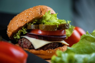 Flütlü tavanın yanında lezzetli bir burger. Bir şef bıçağı. Bir sürü sebze..