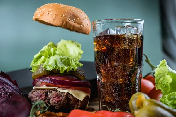 Classic burger and fizzy drink. Homemade hamburger. Meat and vegetables.