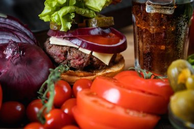 Lezzetli sulu hamburger ve karbonatlı içecek.