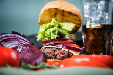 Lezzetli sulu hamburger ve karbonatlı içecek.