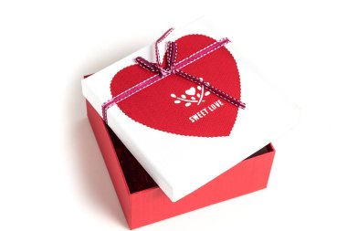Kırmızı ve beyaz hediyeyi parlak bir arka planda kurdeleyle sar. Hediye kutusu.
