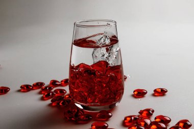 Sevgililer Günü. Bir bardak suda küçük kırmızı cam kalpler. Bir damla sıvı..