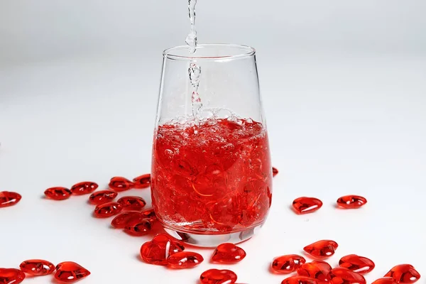 День Святого Валентина Маленькие Красные Стеклянные Сердечки Стакане Воды Всплеск — стоковое фото