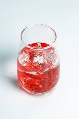 Sevgililer Günü. Bir bardak suda küçük kırmızı cam kalpler. Bir damla sıvı..