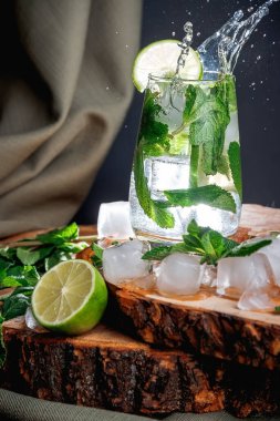 Karanlık bir arka planda mojito kokteyli. Tahta tezgah. Buz ve nane.