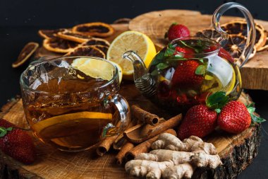 Cam çaydanlık. Limonlu ve çilekli sıcak çayla hayat. Tahta tezgah. Sıçrama.