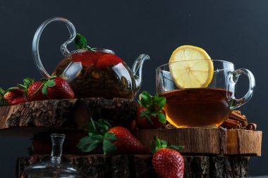 Limonlu ve çilekli sıcak çay. Cam çaydanlık. Tahta tezgah. Sıçrama.