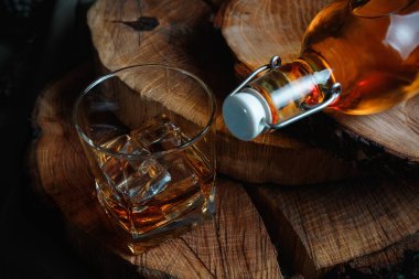 Viski bardağında buz küpleri. Sert alkol. Tahtadan yapılmış dur..