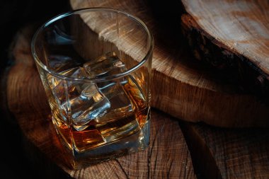 Viski bardağında buz küpleri. Sert alkol. Tahtadan yapılmış dur..