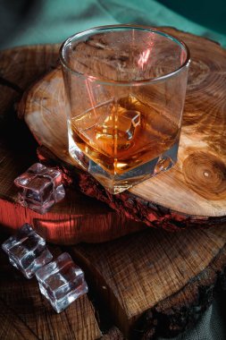 Viski bardağında buz küpleri. Sert alkol. Tahtadan yapılmış dur..