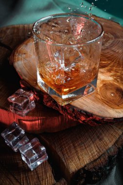 Ahşap yüzeyde buzlu bir bardak viski.