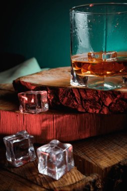 Viski bardağında buz küpleri. Sert alkol. Tahtadan yapılmış dur..