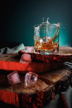 Viski bardağında buz küpleri. Sert alkol. Tahtadan yapılmış dur..