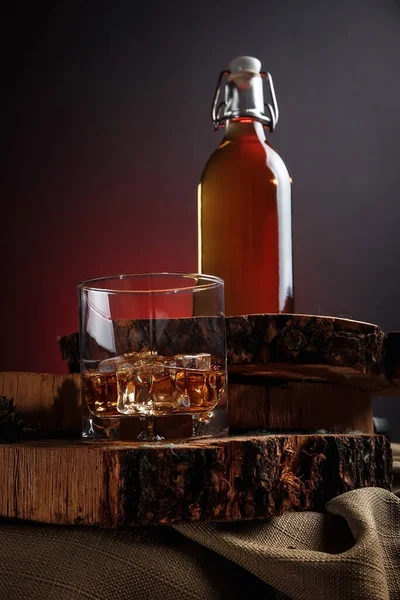 Old whiskey bottle on black wooden table. Drinks on a dark blurred background.