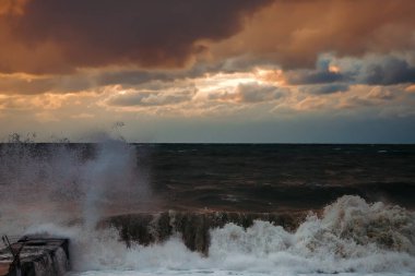 Fırtınadan sonra deniz kıyısında destansı karanlık günbatımı gökyüzü. Dramatik parlak kırmızı bulutlar, doğal doku, arka plan. 
