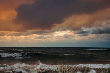 Fırtınadan sonra deniz kıyısında destansı karanlık günbatımı gökyüzü. Dramatik parlak kırmızı bulutlar, doğal doku, arka plan. 