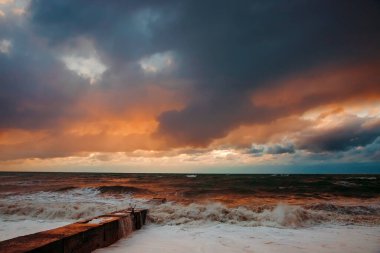 Fırtınadan sonra deniz kıyısında destansı karanlık günbatımı gökyüzü. Dramatik parlak kırmızı bulutlar, doğal doku, arka plan. 