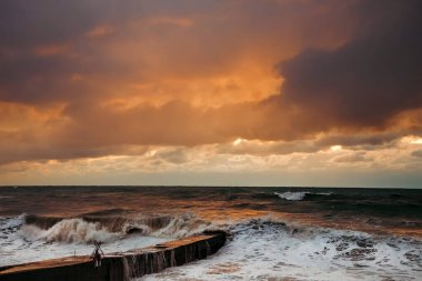 Fırtınadan sonra deniz kıyısında destansı karanlık günbatımı gökyüzü. Dramatik parlak kırmızı bulutlar, doğal doku, arka plan. 