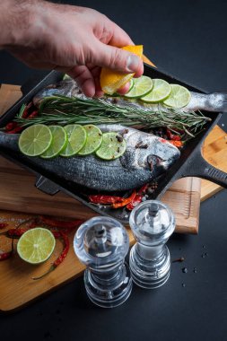 Zeytinyağlı, baharatlı ve limonlu taze deniz balığı pişirmeye hazır. Dorado ya da çipura balığı.. 