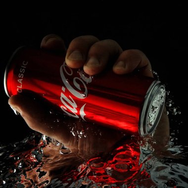 Moskova, Rusya, 7 Nisan 2021. Bir adamın eli bir kutu kola uzatıyor. Su sıçraması ve suyun altında hava kabarcıkları. Siyah arkaplanda izole et.