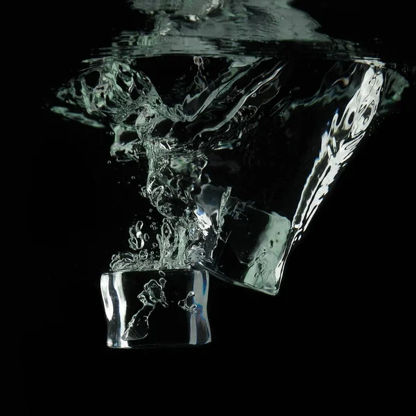 Кубики Льда Падают Воду Изолировать Черном Фоне — стоковое фото