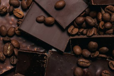 Kahve çekirdekleri ve çikolata. Koyu çikolata. Tarçın renginin doğal arkaplanı.