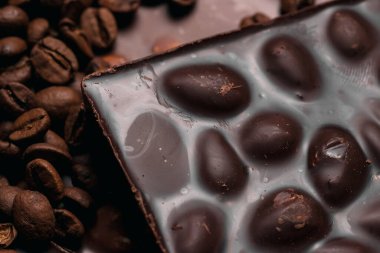 Kahve çekirdekleri ve çikolata. Koyu çikolata. Tarçın renginin doğal arkaplanı.