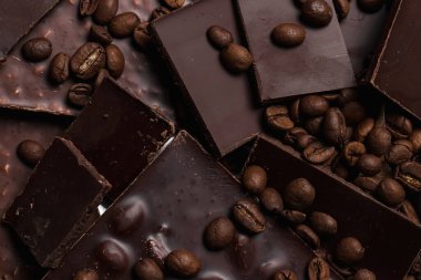 Kahve çekirdekleri ve çikolata. Koyu çikolata. Tarçın renginin doğal arkaplanı.