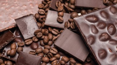 Kahve çekirdekleri ve çikolata. Koyu çikolata. Tarçın renginin doğal arkaplanı.