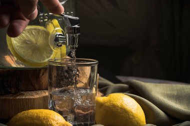 Limonlu ve naneli soğuk su, çeşmeli cam bir kavanozda..