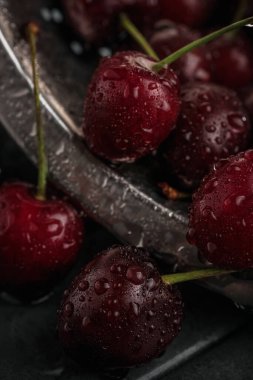 Sulu, olgun vişneli yakın plan. Kırmızı kiraz. makro fotoğraf. Karanlık bir arka planda hayat.