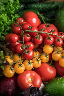 Sarı kiraz domatesleri ve diğer sebzeler. Vejetaryen natürmort. Taze sebzeler. Doğal arkaplan.