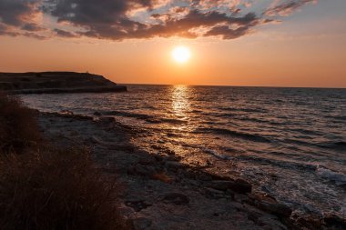 Deniz kıyısındaki taşlar. Gün batımında Rocky Sahili. Doğal arkaplan.