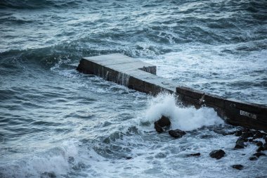 Beton bir iskelede deniz dalgaları kırılır. Dalgakıran. Element.