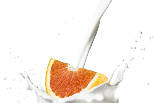 Апельсин, падающий на молочные брызги — стоковое фото