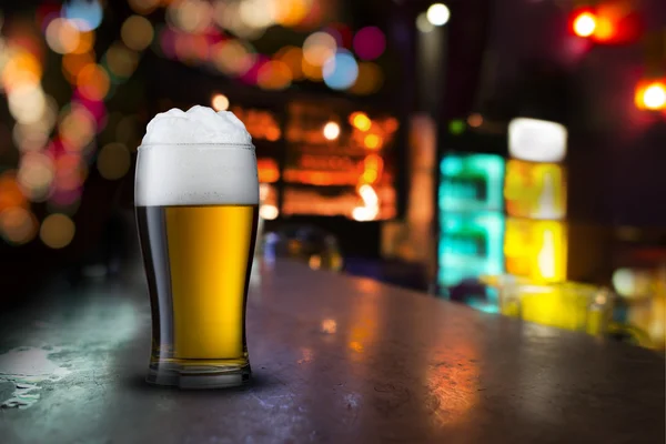 Glass of beer with bar scene — Stock Photo, Image