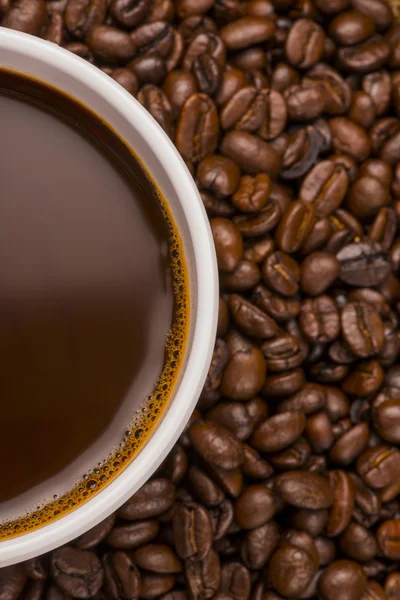 Cup of hot coffee on coffee beans — Stock Photo, Image