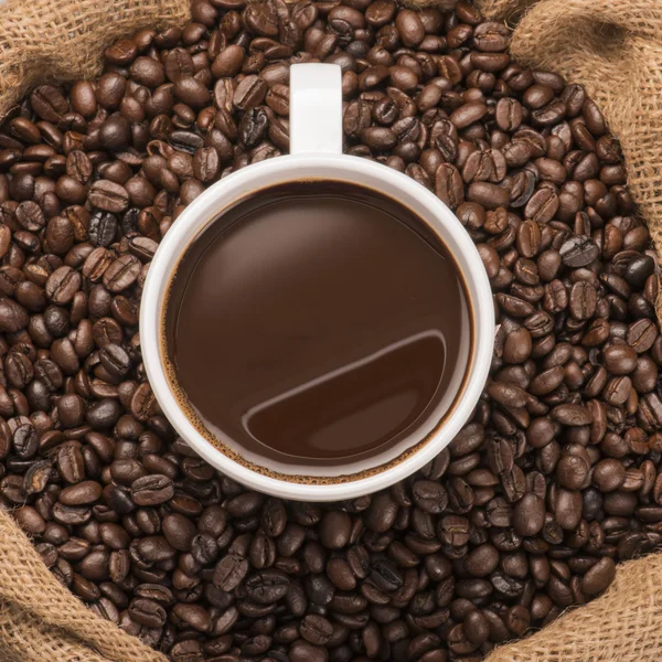 Tasse heißen Kaffee auf Kaffeebohnen — Stockfoto