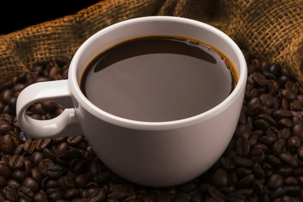 Kopp varmt kaffe på kaffebönor — Stockfoto