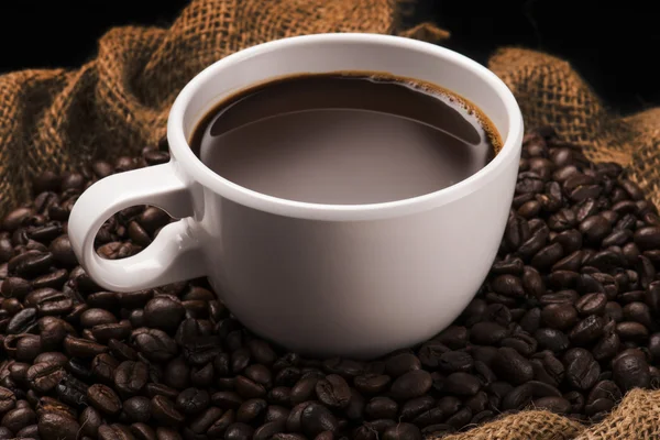 Tasse heißen Kaffee auf Kaffeebohnen — Stockfoto