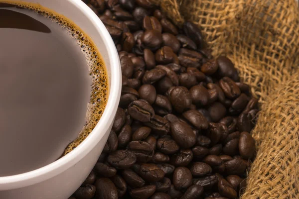 Tasse heißen Kaffee auf Kaffeebohnen — Stockfoto