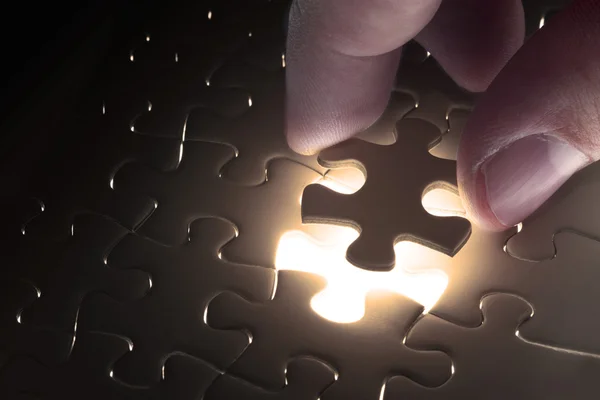 Missing jigsaw puzzle piece with light glow — Stock Photo, Image