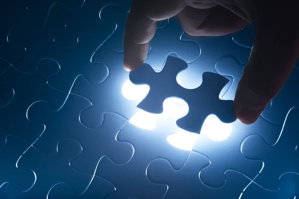 Missing jigsaw puzzle piece with light glow — Stock Photo, Image