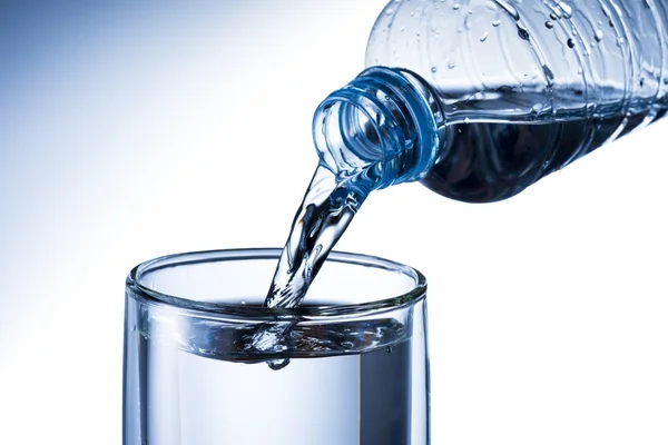 Versare acqua dalla bottiglia d'acqua al vetro — Foto Stock