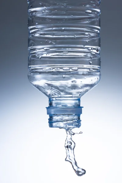 Verser l'eau de la bouteille d'eau au verre — Photo