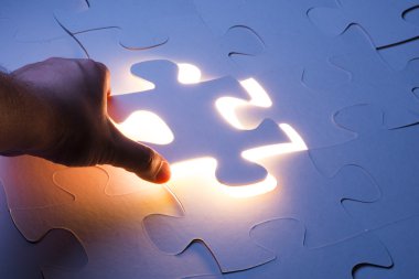 Eksik yapboz bulmaca parçası tutan el