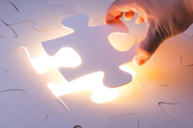 Eksik yapboz bulmaca parçası tutan el