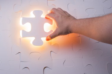 Eksik yapboz bulmaca parçası tutan el