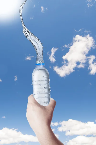 Bottiglia con spruzzi d'acqua in mano — Foto Stock