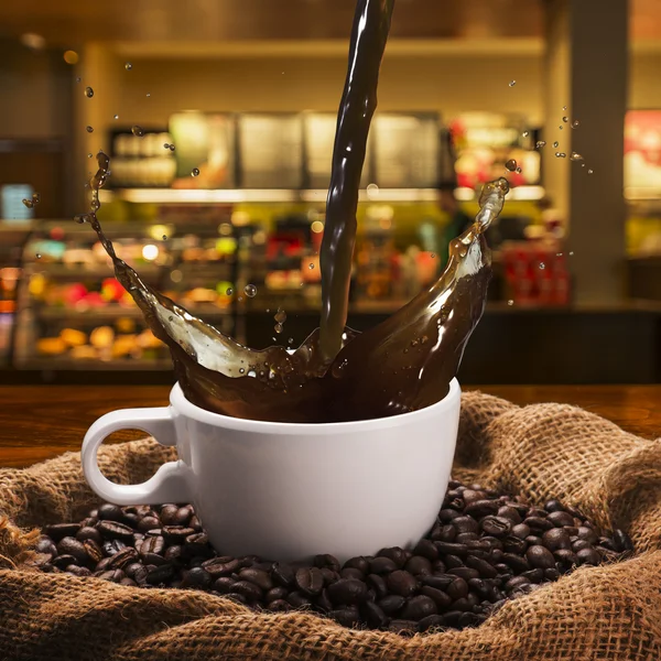 Salpicaduras de café caliente en taza — Foto de Stock